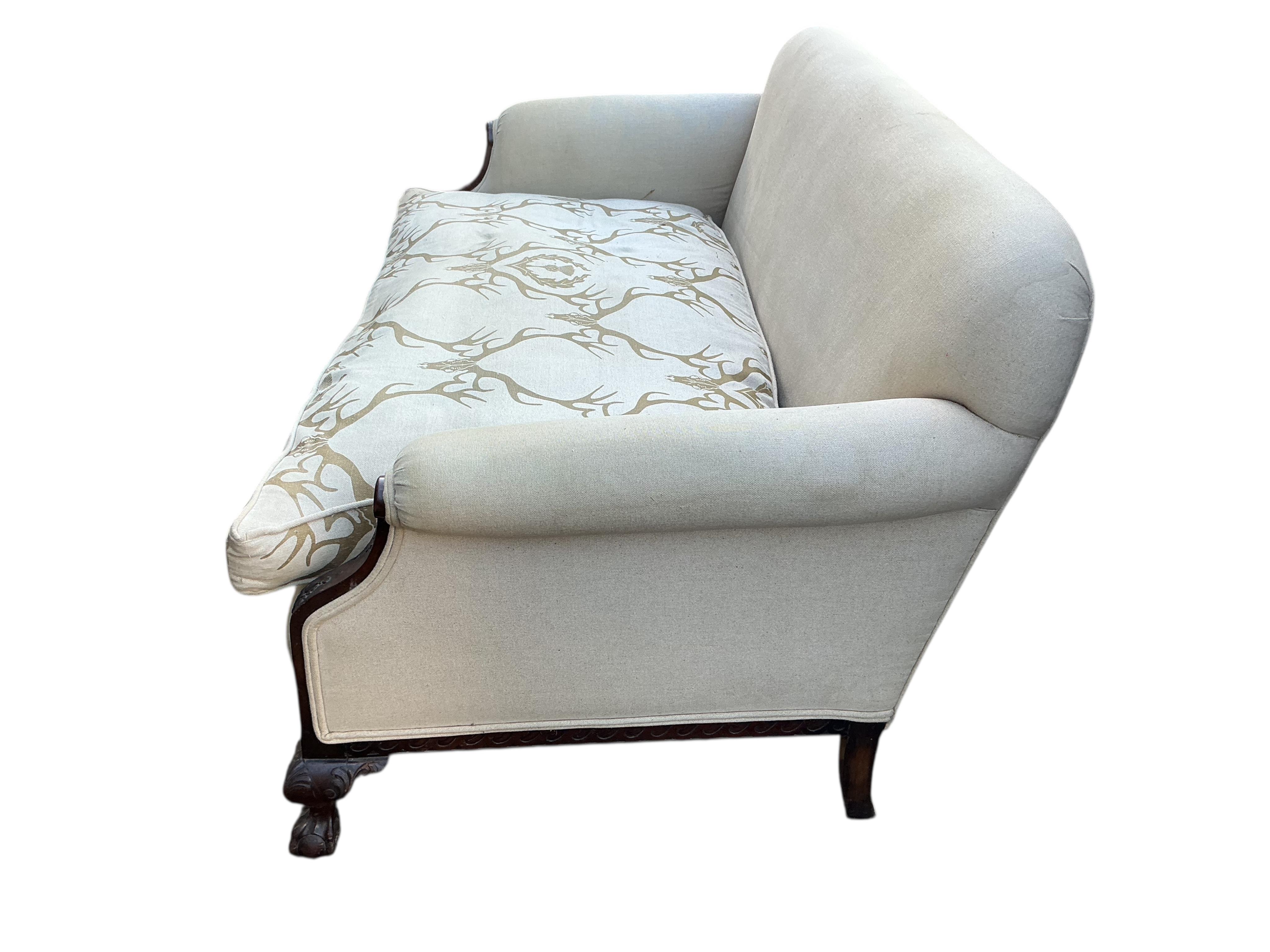 An early 20th century upholstered settee with stag head printed cushion seat, width 150cm, depth 84cm, height 76cm